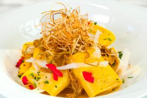 a white plate of food with pineapple and noodles at Glemerald Hostel in Pula