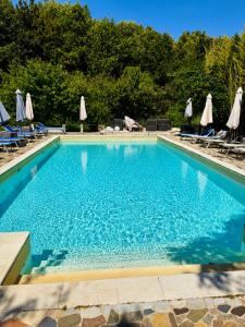 a large swimming pool with chairs and umbrellas at La Collina Dei Castagni in Terni