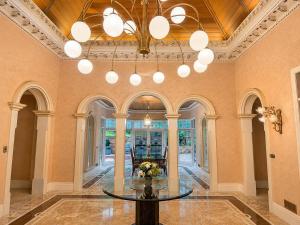 a large room with a glass table and a chandelier at Oak Hill House - Chirnside Park in Wonga Park