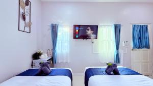 two beds with teddy bears on them in a bedroom at I Hug Homestay ไอฮัก ที่พักเชียงใหม่ in Ban Thap Dua