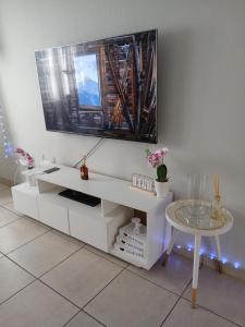 a white entertainment center with a tv on a wall at Cousy Corner in Roodepoort