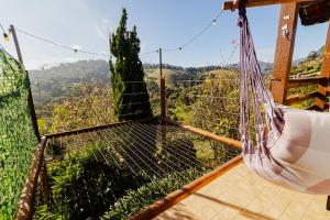 a hammock on a deck with a view of the mountains at Refugio nas Alturas LANDIN & CHARM in Santo Antônio do Pinhal