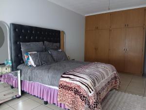 a bedroom with a large bed with a black headboard at Cousy Corner in Roodepoort