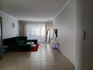 a living room with a couch and a table at Cousy Corner in Roodepoort +1 photo