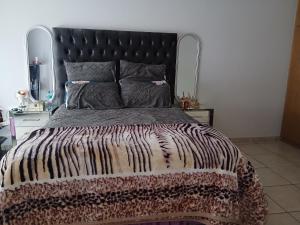 a bedroom with a large bed with a black headboard at Cousy Corner in Roodepoort