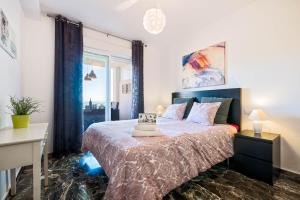 um quarto com uma cama grande e uma janela em Carvajal Luxury Apartments em Fuengirola