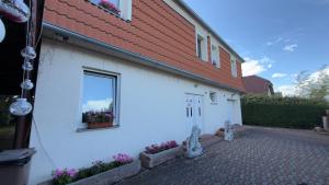 a white building with a window and some flowers at Sabina house in Vestec