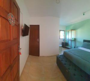 a bedroom with a bed and a door with a couch at Villa Maze Suites - Canoa Quebrada in Aracati