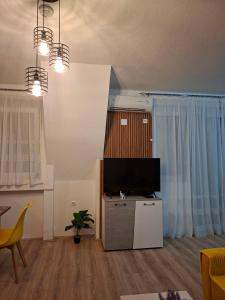 a living room with a flat screen tv on a table at M & A Apartmani in Kumanovo