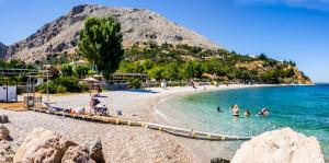 a group of people swimming in the water on a beach at Chios Studios Kalamari in Vrontádos