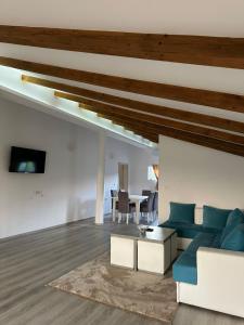 a living room with a blue couch and a table at Kelesina Apartment in Ulcinj