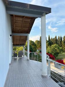 a wooden deck with chairs and a wooden roof at Kelesina Apartment in Ulcinj