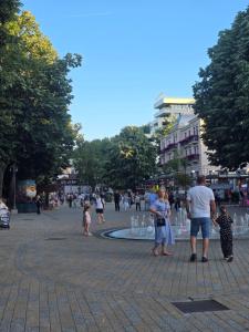 a group of people walking around a fountain in a city at Green Diamond in Vrnjci