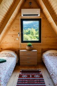 two beds in a room with a window at Trebižat Oasis in Čapljina