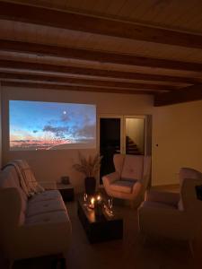 a living room with two couches and a large screen at Dom na Kaszubach, Żuromino 2 0 in Żuromino