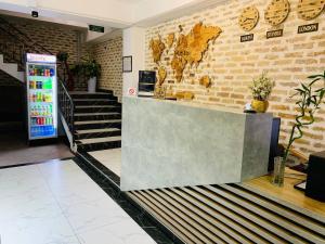 a lobby with a reception counter and a brick wall at Hotel Hirot in Tashkent