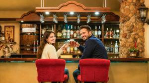 a man and woman sitting at a bar drinking at Mazurska Chata jezioro i aquapark 6 min, centrum i promenada 12 min in Mikołajki