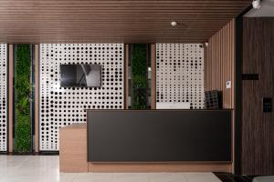 a lobby with a reception desk with a tv on a wall at Gulshan Hotel in Urganch