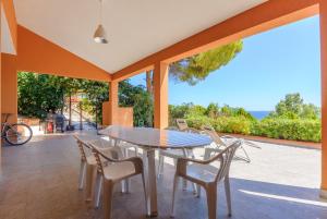 a dining room with a table and chairs on a patio at Piccola Baia in Scopello