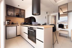 a kitchen with white cabinets and a stove top oven at Latsis Suites in Plytra +19 photos