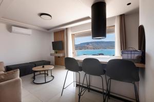 a living room with a table and chairs and a window at Latsis Suites in Plytra