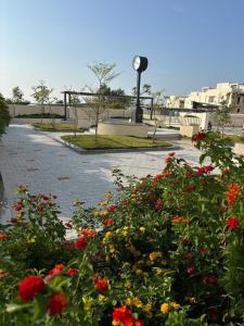 a street with flowers and a clock in the background at Coastal villa in Tirupporūr