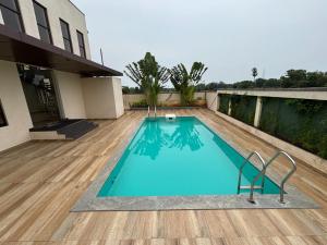 a swimming pool with two chairs next to a house at Coastal villa in Tirupporūr