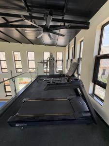 a large room with a ceiling fan and a gym at Coastal villa in Tirupporūr
