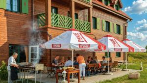 a group of people sitting at a restaurant under umbrellas at Mazurska Chata jezioro i aquapark 6 min, centrum i promenada 12 min in Mikołajki