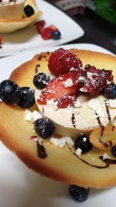 a piece of fruit with berries on a white plate at Hotel Villa Milano in Peio Fonti