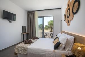 a bedroom with a bed and a window with a table at GK Home Studios part of GK FITNESS CLUB in Faliraki