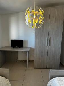 a bedroom with a desk and a yellow chandelier at L'attico di Greta,Etna house in Mascalucia