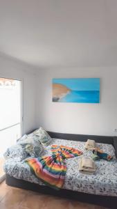 a bedroom with a bed with a colorful blanket on it at CasAdri Tenerife in Arona