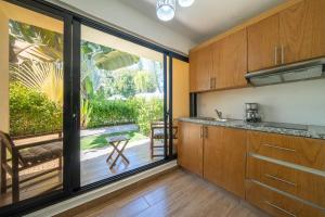 a kitchen with wooden cabinets and a large window at Tropical Casa Laguna in Cabarete