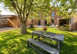 a wooden picnic table in a yard with a tree at Le Clos Boréal - Gîte Spa Privatif in Lens