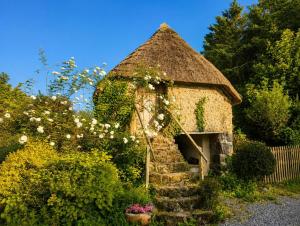 a small stone house with a grass roof at Mabel the Steam Roller Caravan at Rosuick Organic Farm in Saint Martins Green