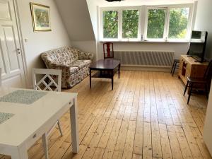 a living room with a couch and a table at Lilla Skolhuset i Ingelsträde in Höganäs