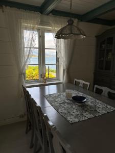 a dining room with a table and chairs and a window at Heritage House in Lofoten with Modern Comfort & Scenic Views in Jerstad