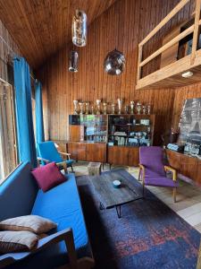 ein Wohnzimmer mit einem blauen Sofa und lila Stühlen in der Unterkunft Vila Strėva in Kozelkiskes