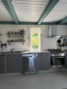 a kitchen with stainless steel appliances and a window at Heritage House in Lofoten with Modern Comfort & Scenic Views in Jerstad