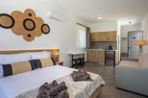 a bedroom with a large bed and a kitchen at GK Home Studios part of GK FITNESS CLUB in Faliraki
