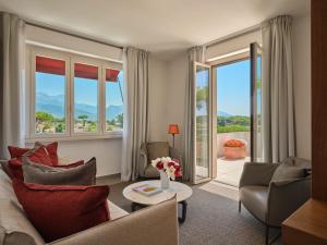a living room with a couch and chairs and windows at La Serena Forte dei Marmi, Small Luxury Hotels of the World in Forte dei Marmi