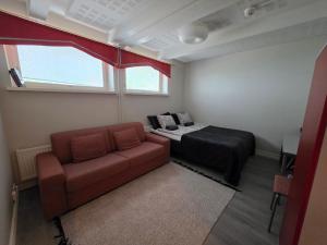 a room with a couch and a bed and a window at Apartments Puistokatu in Savonlinna