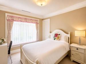 a bedroom with a large white bed and a window at Campus Haven Near YVR UBC Downtown in Vancouver