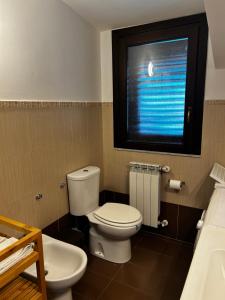 a bathroom with a white toilet and a window at L'attico di Greta,Etna house in Mascalucia +24 photos