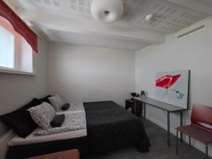 a bedroom with a bed and a desk and a red chair at Apartments Puistokatu in Savonlinna