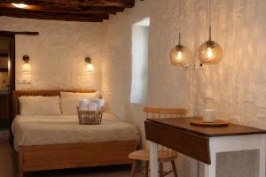 a bedroom with a bed and a desk and lights at NeSi Cycladic Living in Ano Syros