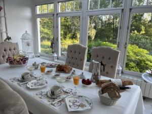 a table with a white table cloth with food on it at Les 4 saisons in Menneville +3 photos