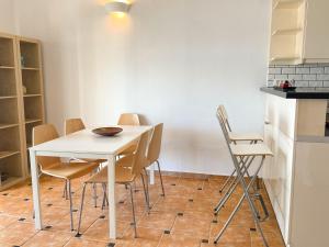 a dining room with a white table and chairs at Gaia Skiathos Apartments in Achladies
