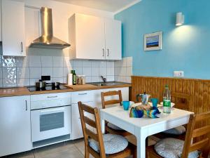 a kitchen with a white table and two chairs and a sink at Apartamento Los Lagos Renovated New Kitchen & More in El Cotillo